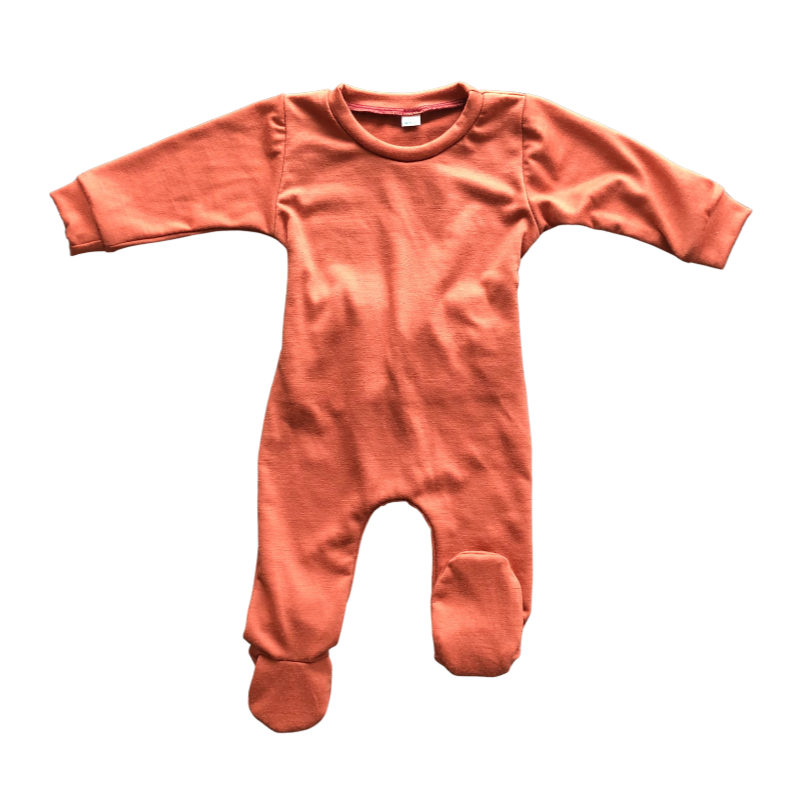 Flat lay of the front of a sleep suit with one foot up