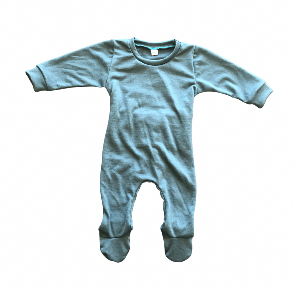 Flat lay of a merino baby grow in Soft Teal against a white back ground